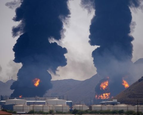 Plumes of smoke and fire rise after debris from an intercepted Iranian drone struck an oil facility, according to authorities, in Fujairah, United Arab Emirates, Saturday, March 14, 2026. (AP Photo/Altaf Qadri)