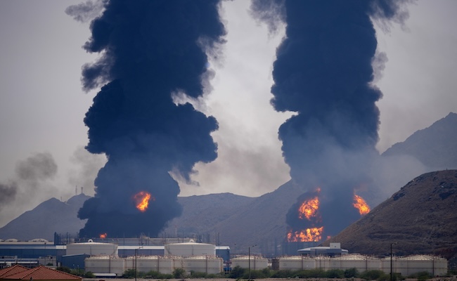 Plumes of smoke and fire rise after debris from an intercepted Iranian drone struck an oil facility, according to authorities, in Fujairah, United Arab Emirates, Saturday, March 14, 2026. (AP Photo/Altaf Qadri)