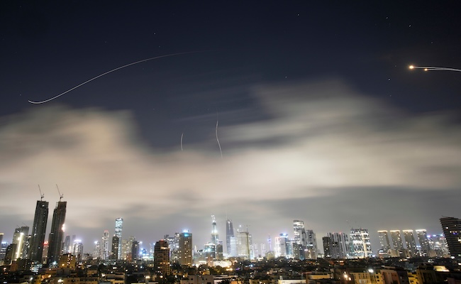 Israeli air defense system fires to intercept missiles during an Iranian attack over Tel Aviv, Israel, early Sunday, March 15, 2026. (AP Photo/Ohad Zwigenberg)