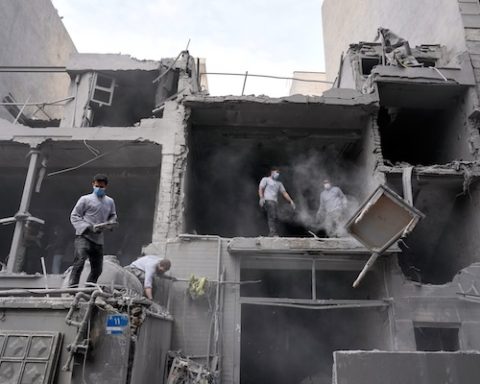 Volunteers clean debris from a residential building damaged when a nearby police station was hit Friday in a U.S.-Israeli strike in Tehran, Iran, Sunday, March 15, 2026. (AP Photo/Vahid Salemi)