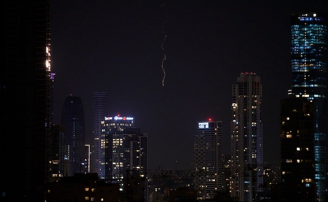 Missiles launched from Iran streak across the sky over central Israel, early Monday, March 23, 2026. (AP Photo/Ohad Zwigenberg)
