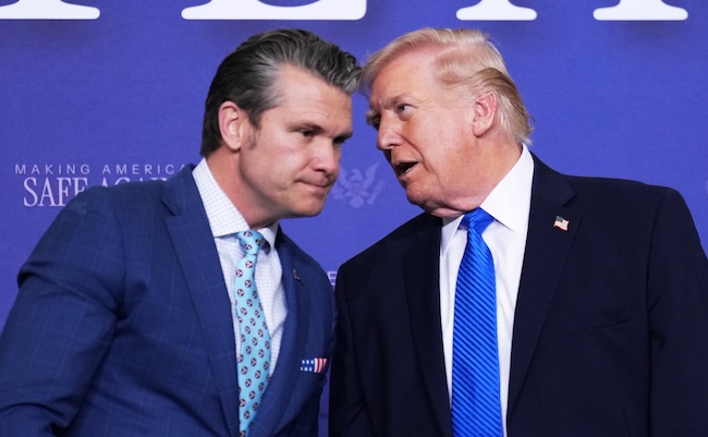 President Donald Trump speaks with Defense Secretary Pete Hegseth during a roundtable discussion on public safety at a Tennessee Air National Guard Base, Monday, March 23, 2026, in Memphis, Tenn. (AP Photo/Mark Schiefelbein)