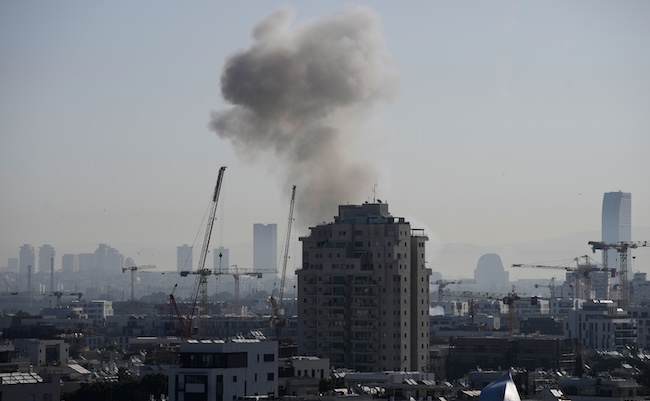 Smoke billows following an Iranian missile strike in Tel Aviv, Tuesday, March 24, 2026. (AP Photo/Ohad Zwigenberg)