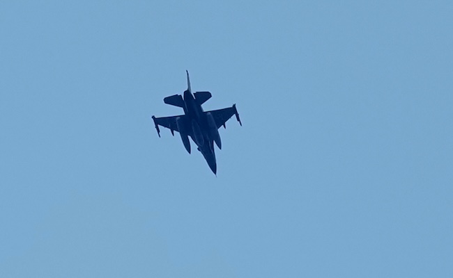 An Israeli warplane flies over the city of Tyre, south Lebanon, Wednesday, March 25, 2026. (AP Photo/Hussein Malla)