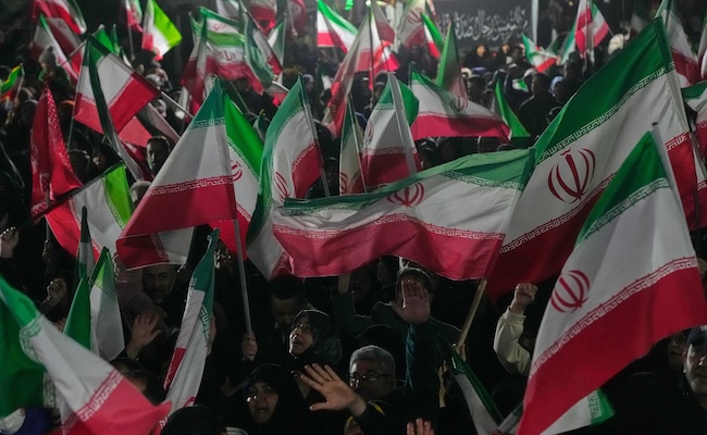 Pro-government supporters wave Iranian flags during a rally in a square in western Tehran, Iran, Wednesday, March 25, 2026. (AP Photo/Vahid Salemi)