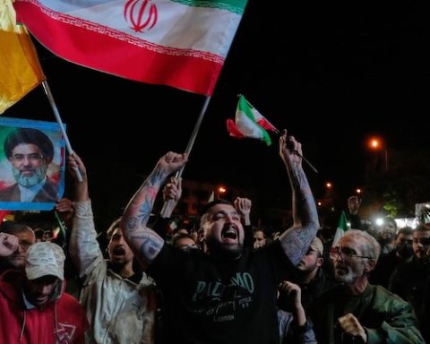 Pro-government demonstrators chant slogans as they hold Iranian flags and a poster of the Supreme Leader Ayatollah Mojtaba Khamenei in a gathering after announcement of a two-week ceasefire in the war with the United States and Israel, at the Enqelab-e-Eslami, or Islamic Revolution, Square, in Tehran, Iran, Wednesday, April 8, 2026. (AP Photo/Vahid Salemi)