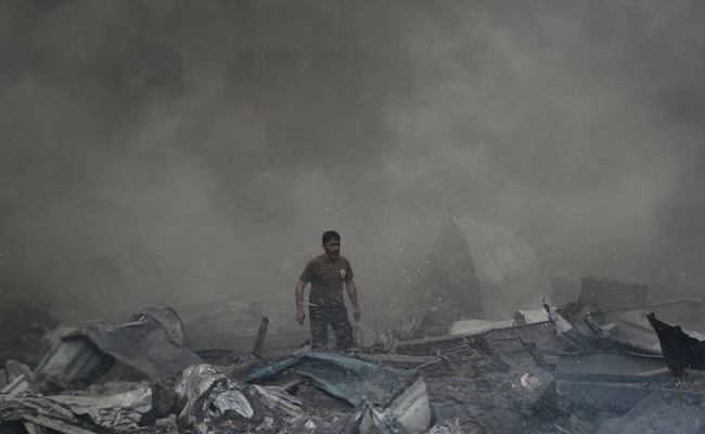 A first responder emerges through the smoke at the site of an Israeli airstrike that struck an apartment building in Beirut, Lebanon, Wednesday, April 8, 2026. (AP Photo/Bilal Hussein)