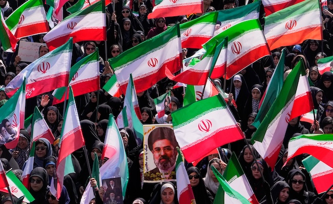 Women hold Iranian flags and a portrait of Supreme Leader Ayatollah Mojtaba Khamenei during a state-organized rally in support of the supreme leader marking National Girl's Day in Tehran, Iran, Friday, April 17, 2026. (AP Photo/Vahid Salemi)