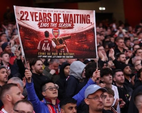 LONDON, ENGLAND - MAY 18: An Arsenal fan holds up a sign saying ' 22 years of waiting ends this season' in reference to Arsenal possibly winning the Premier League ahead of the Premier League match between Arsenal and Burnley at Emirates Stadium on May 18, 2026 in London, England. (Photo by Catherine Ivill - AMA/Getty Images)