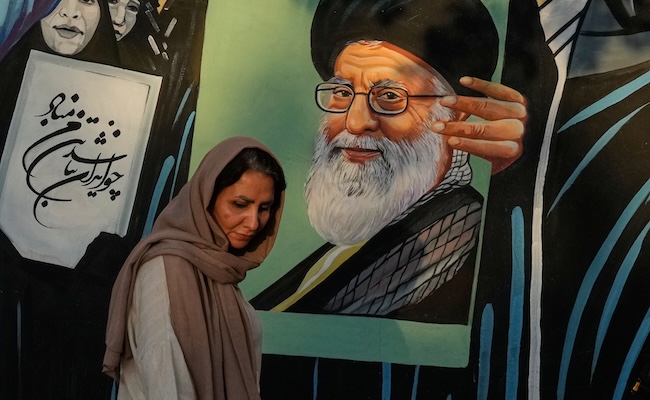 A woman walks past a mural depicting a portrait of the late Iranian Supreme Leader Ayatollah Ali Khamenei, who was killed in the U.S. and Israel strike on Feb. 28, in downtown Tehran, Iran, Saturday, July 18, 2026. (AP Photo/Vahid Salemi)